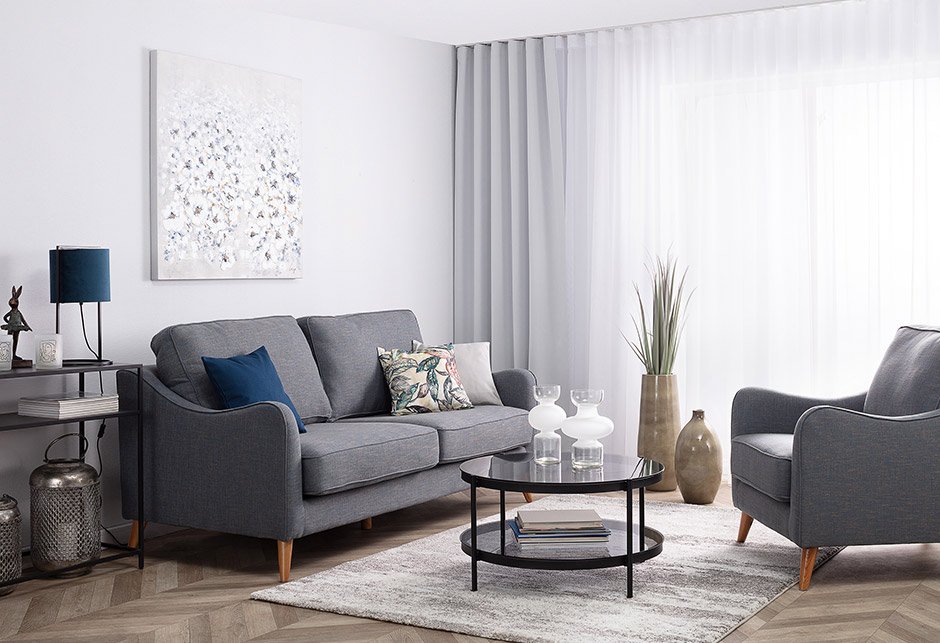 Szara sofa tapicerowana w nowoczesnym salonie